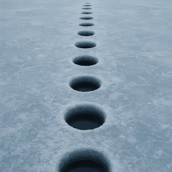 Ровный ряд учебных лунок на льду с одинаковым расстоянием между ними