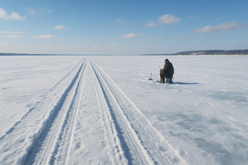 Широкое замёрзшее водохранилище с уходящими вдаль следами маршрута